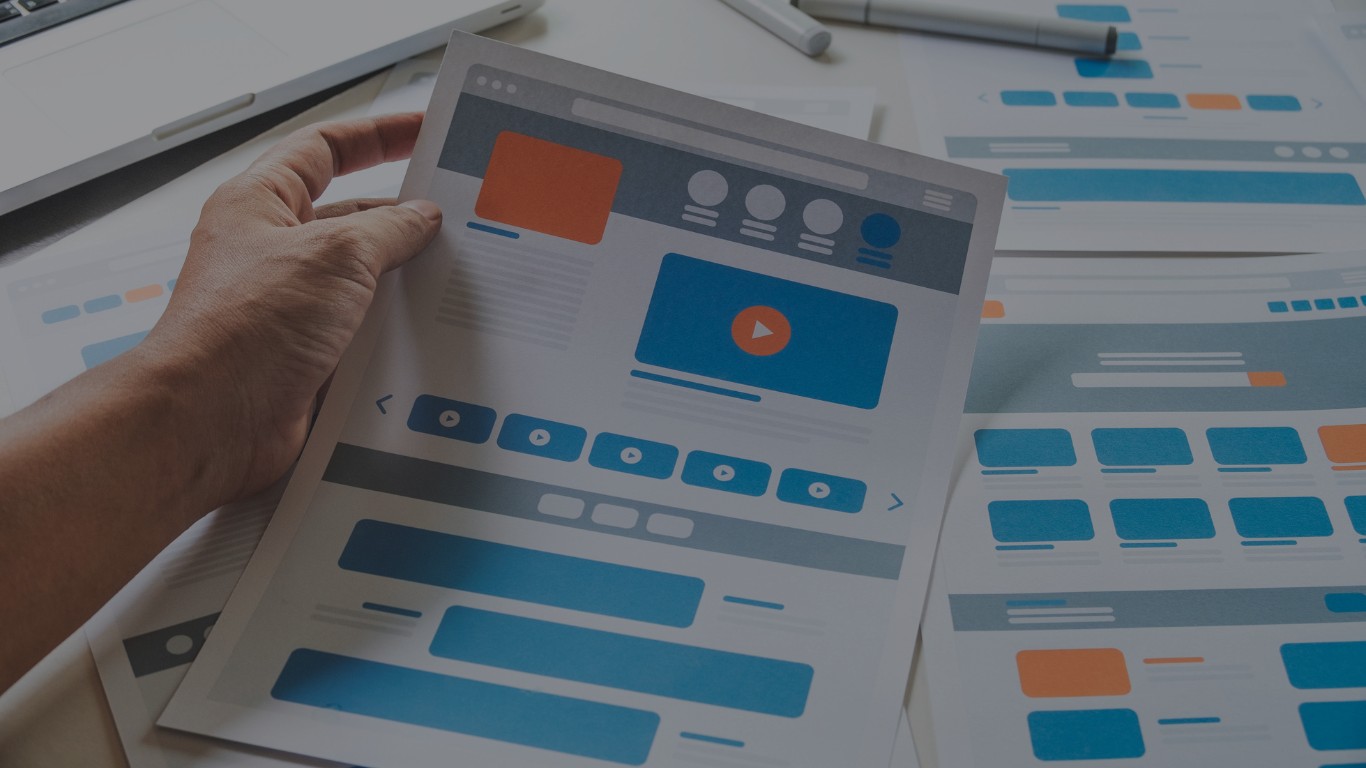 Mano sosteniendo impresiones de maquetas de diferentes tipos de páginas web, ilustrando la diversidad de categorías y diseños disponibles.